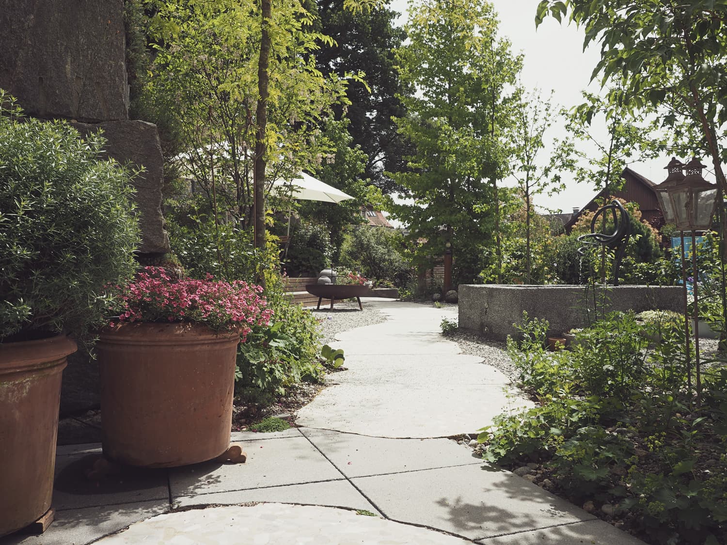 Foto von Steinweg mit Feuerstelle und Brunnen im Hintergrund